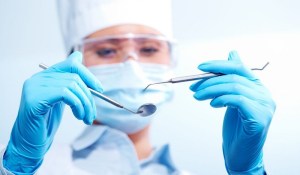 Dentist holding dental tool &mdash; professional guidance for selecting your cosmetic dentist